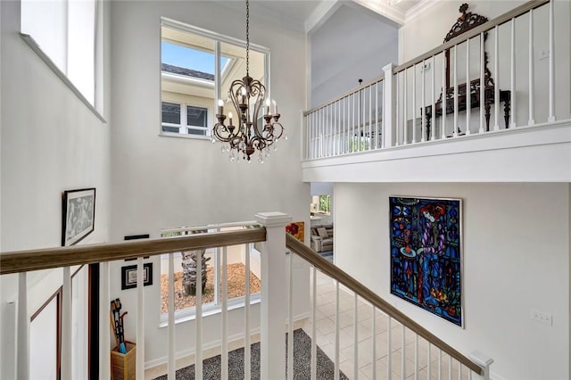 staircase with a notable chandelier and a towering ceiling