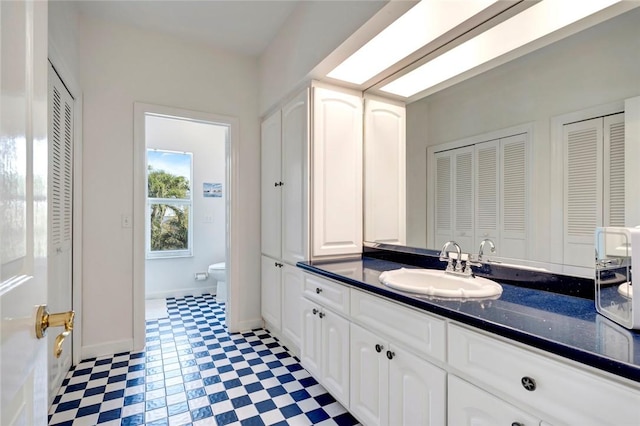 bathroom with tile patterned floors, a closet, toilet, and vanity