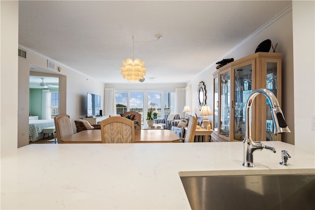 kitchen with ornamental molding, a textured ceiling, and sink