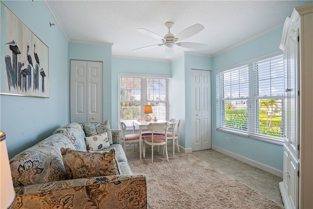 living area with a textured ceiling, a healthy amount of sunlight, crown molding, and ceiling fan