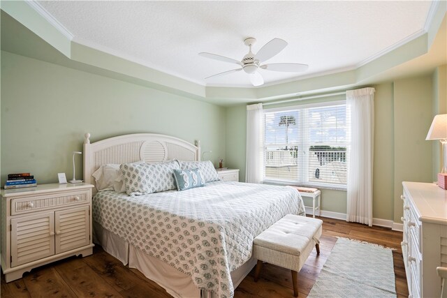 bedroom with dark hardwood / wood-style flooring, ceiling fan, and crown molding