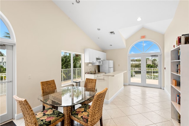 dining area with high vaulted ceiling, sink, a healthy amount of sunlight, and french doors