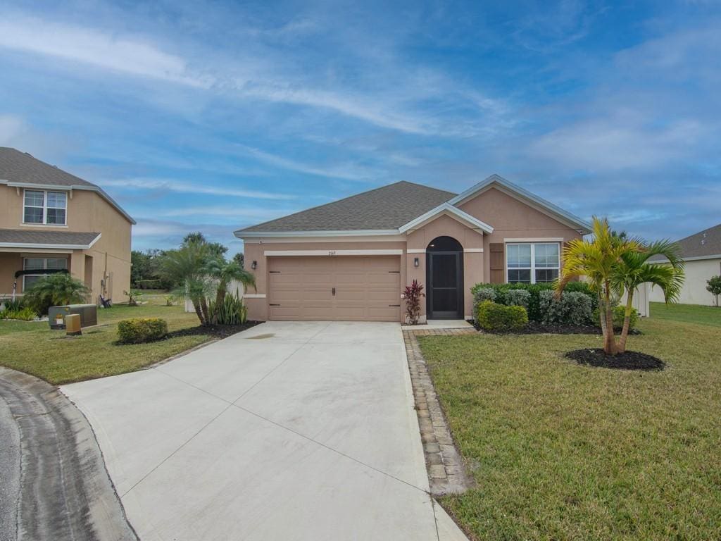 ranch-style house with a front yard and a garage