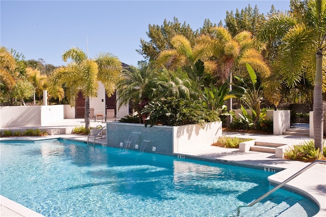 view of swimming pool featuring pool water feature and a patio area