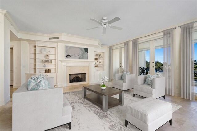 living room with built in features, french doors, ceiling fan, and crown molding