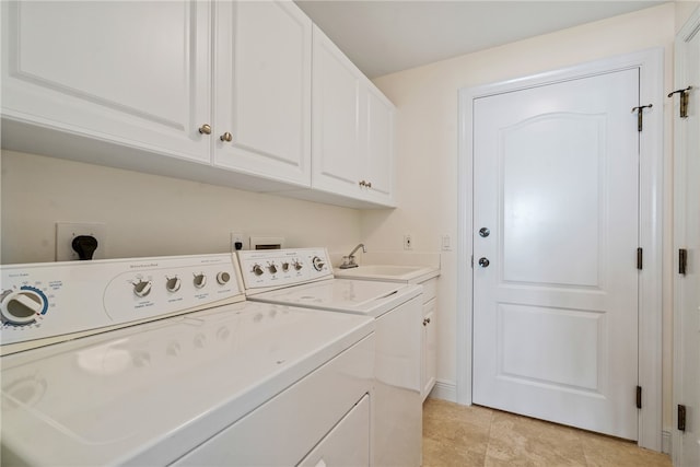 laundry area featuring cabinets, washing machine and dryer, light tile patterned floors, and sink