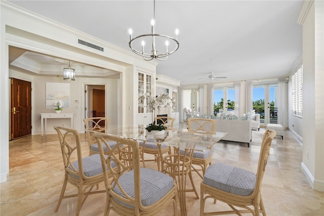 dining space with ceiling fan with notable chandelier and crown molding