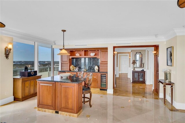 kitchen featuring hanging light fixtures, a kitchen breakfast bar, a center island, ornamental molding, and beverage cooler