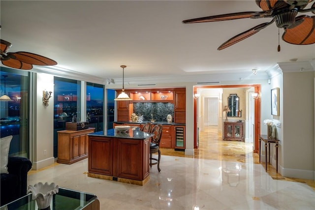 kitchen featuring beverage cooler, hanging light fixtures, a center island, ceiling fan, and crown molding