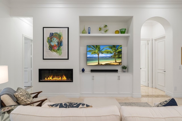 living room with built in shelves and ornamental molding