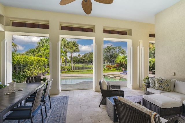 sunroom / solarium featuring ceiling fan and a healthy amount of sunlight