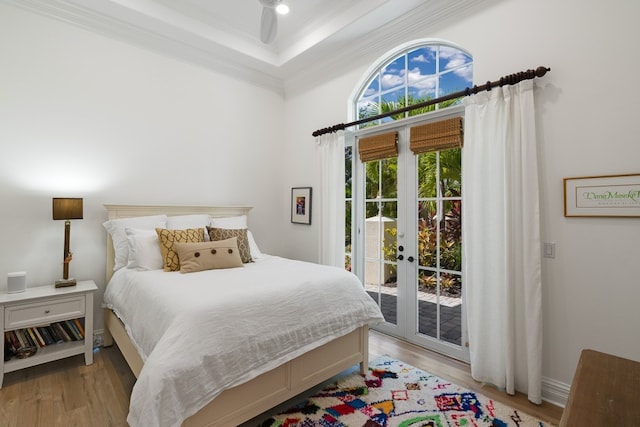 bedroom featuring french doors, ornamental molding, light hardwood / wood-style flooring, and access to outside