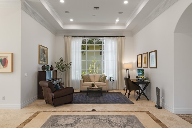 sitting room with ornamental molding and a raised ceiling