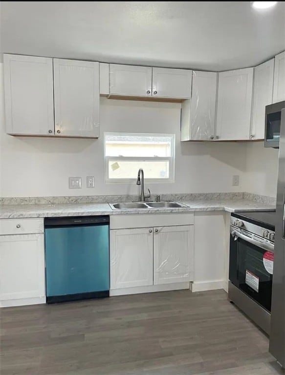 kitchen featuring white cabinets, appliances with stainless steel finishes, sink, and dark hardwood / wood-style flooring