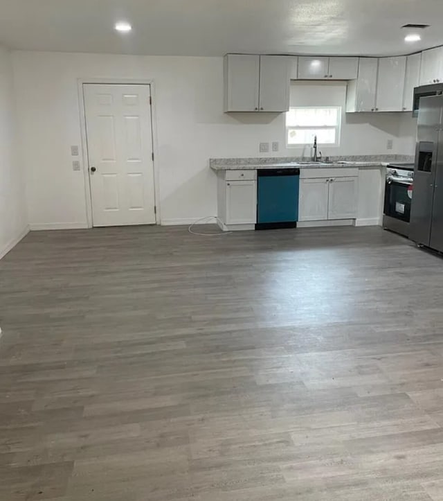 kitchen with white cabinets, sink, light hardwood / wood-style flooring, and appliances with stainless steel finishes