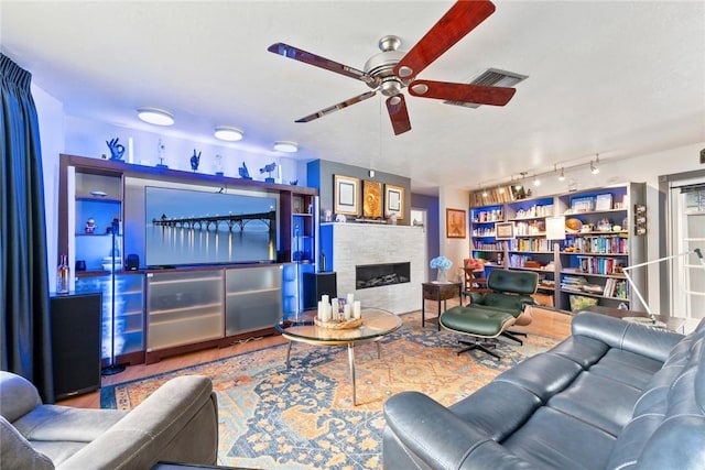 5541 Teal Ter, Fort Pierce, FL 34982 - living room with a ceiling fan, a fireplace, track lighting, and wood finished floors