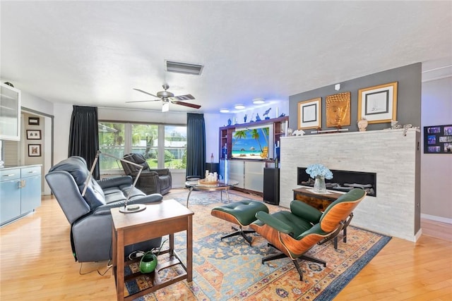5541 Teal Ter, Fort Pierce, FL 34982 - living room with light wood-type flooring, a fireplace, a ceiling fan, and baseboards