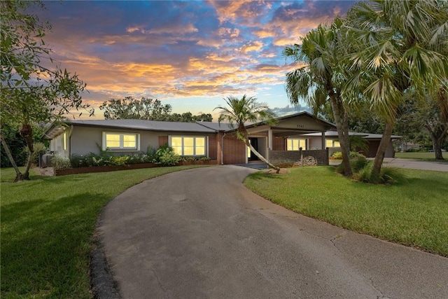 5541 Teal Ter, Fort Pierce, FL 34982 - ranch-style house featuring asphalt driveway, a front lawn, and an attached carport
