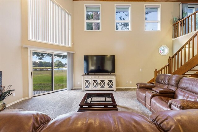 420 Sopwith Dr, Vero Beach, FL 32968 - carpeted living area with stairway, healthy amount of natural light, a high ceiling, and baseboards