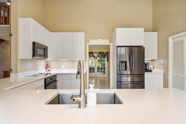 420 Sopwith Dr, Vero Beach, FL 32968 - kitchen featuring black appliances, a sink, light countertops, and white cabinets