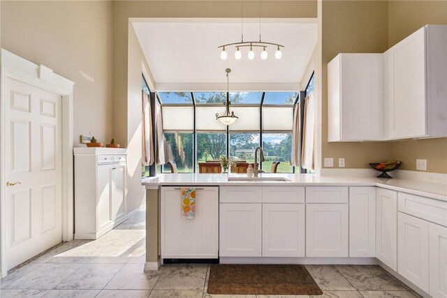 420 Sopwith Dr, Vero Beach, FL 32968 - kitchen with a sink, paneled dishwasher, white cabinets, light countertops, and pendant lighting