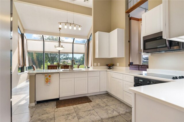 420 Sopwith Dr, Vero Beach, FL 32968 - kitchen featuring stainless steel microwave, a sink, black electric stovetop, white cabinetry, and decorative light fixtures