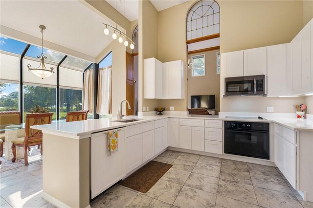 420 Sopwith Dr, Vero Beach, FL 32968 - kitchen featuring stainless steel microwave, black oven, a sink, dishwasher, and white cabinets