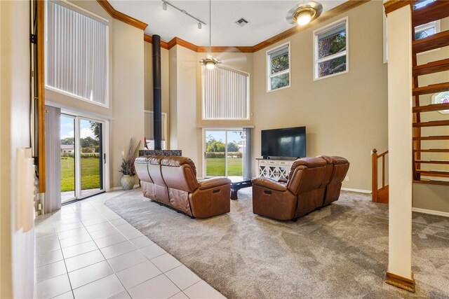 420 Sopwith Dr, Vero Beach, FL 32968 - carpeted living area featuring rail lighting, healthy amount of natural light, a high ceiling, ornamental molding, and tile patterned floors