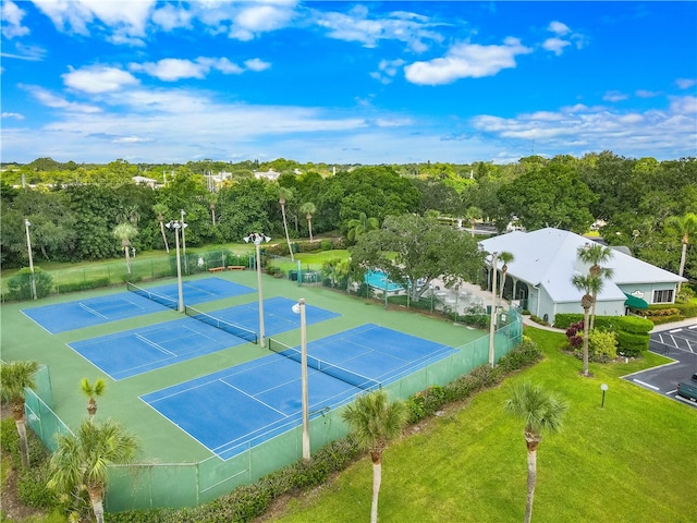 view of tennis court featuring a yard