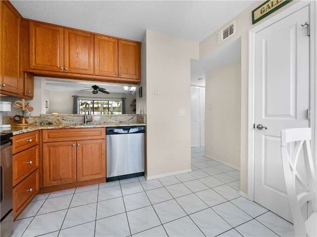 kitchen featuring sink, light stone countertops, ceiling fan, light tile patterned floors, and stainless steel dishwasher