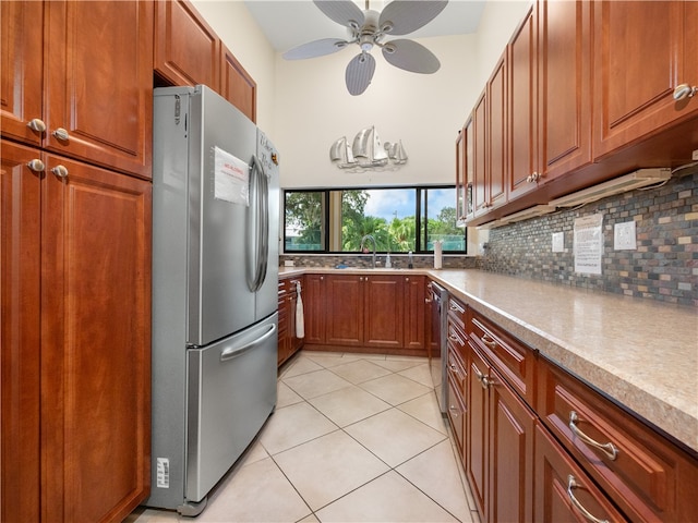 kitchen with sink, appliances with stainless steel finishes, tasteful backsplash, ceiling fan, and light tile patterned floors