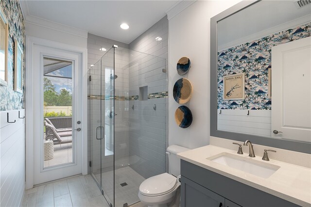 bathroom with toilet, vanity, ornamental molding, and an enclosed shower