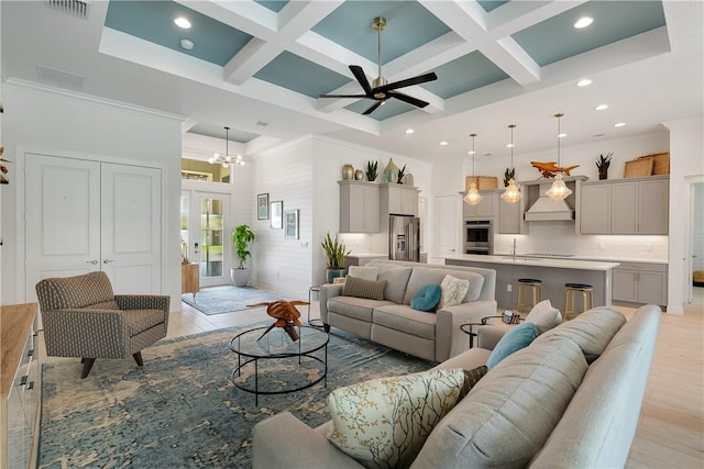 living room featuring ceiling fan with notable chandelier, coffered ceiling, and beamed ceiling