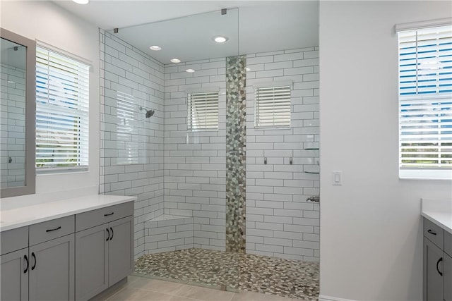 bathroom with vanity, tile patterned flooring, and tiled shower