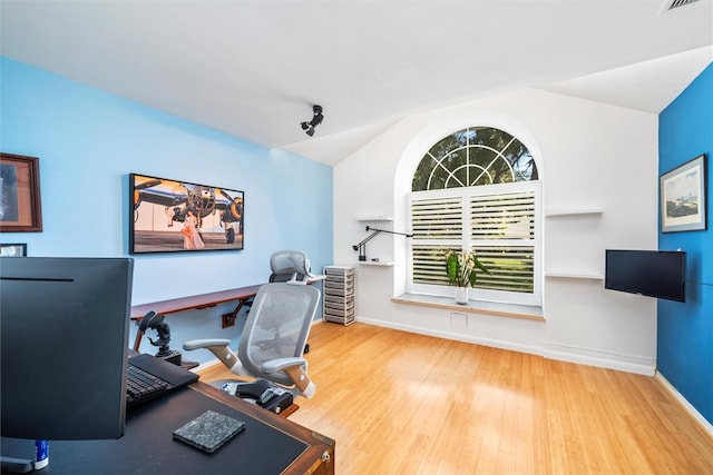 home office with wood-type flooring and lofted ceiling