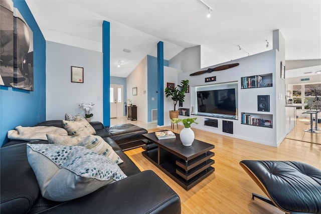 living room featuring hardwood / wood-style floors, high vaulted ceiling, and track lighting