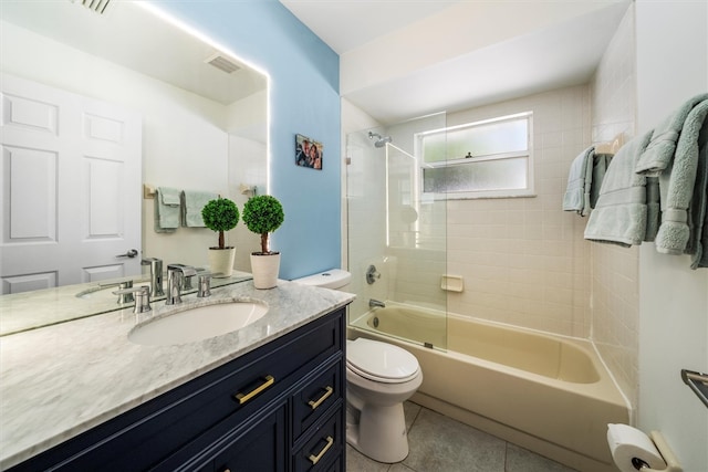 full bathroom with tile patterned floors, vanity, tiled shower / bath combo, and toilet