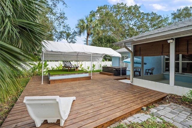 wooden deck with a hot tub and a sunroom