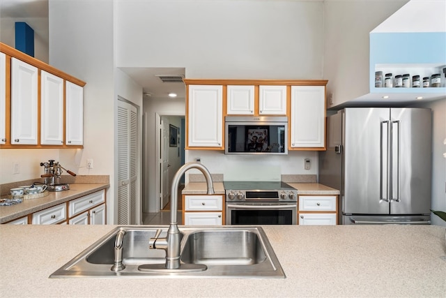 kitchen with white cabinetry, sink, and stainless steel appliances