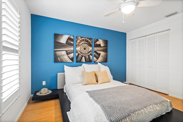 bedroom with hardwood / wood-style floors, a closet, and ceiling fan