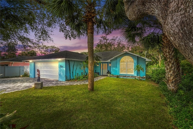 single story home with a lawn and a garage