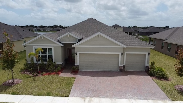 102 52nd Sq, Vero Beach, FL 32967 - view of front facade featuring stucco siding, decorative driveway, an attached garage, a front yard, and a shingled roof
