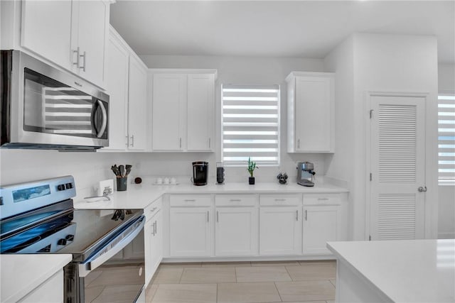 102 52nd Sq, Vero Beach, FL 32967 - kitchen with stainless steel appliances, white cabinets, and light countertops
