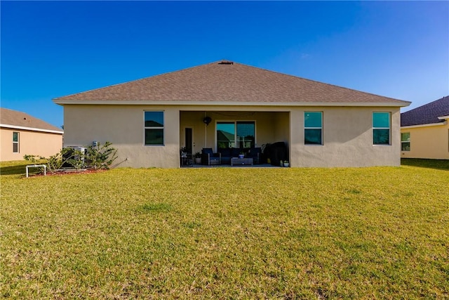 102 52nd Sq, Vero Beach, FL 32967 - back of property featuring roof with shingles, a patio area, stucco siding, and a lawn