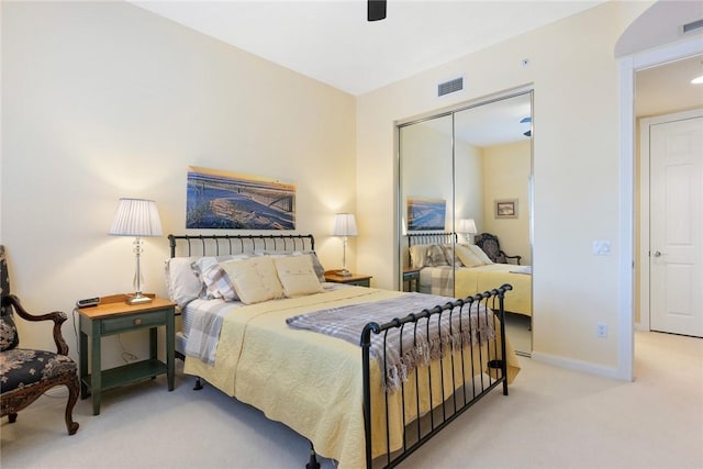 carpeted bedroom featuring ceiling fan and a closet