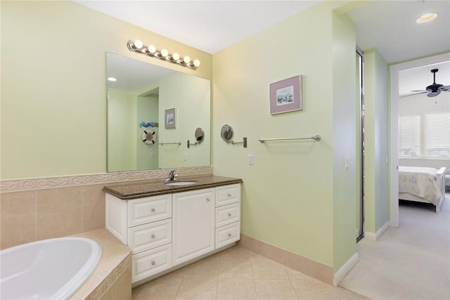 bathroom featuring vanity, tile patterned floors, ceiling fan, and tiled tub