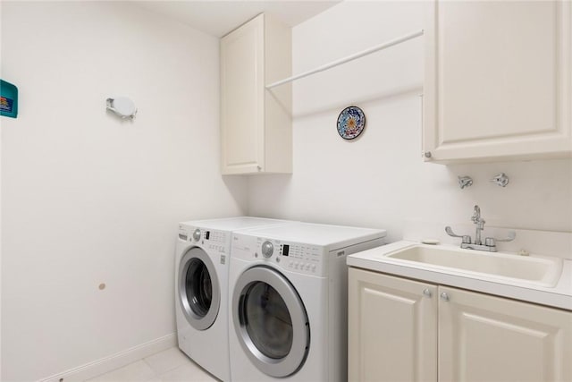 laundry area with cabinets, sink, light tile patterned floors, and washer and dryer