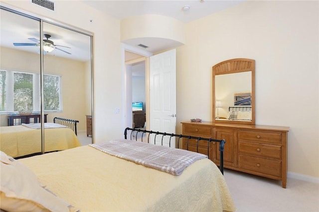 bedroom featuring light carpet, a closet, and ceiling fan