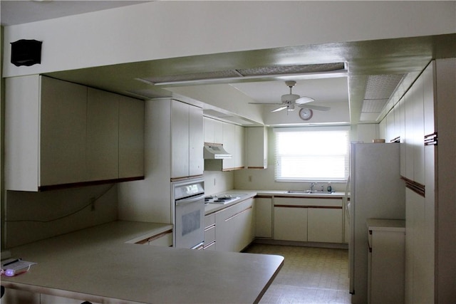 2910 59th Ave, Vero Beach, FL 32966 - kitchen with white appliances, under cabinet range hood, ceiling fan, a peninsula, and light countertops