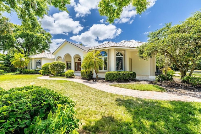 1765 E Rosewood Ct, Vero Beach, FL 32966 - mediterranean / spanish-style home with stucco siding, a front lawn, a standing seam roof, and metal roof